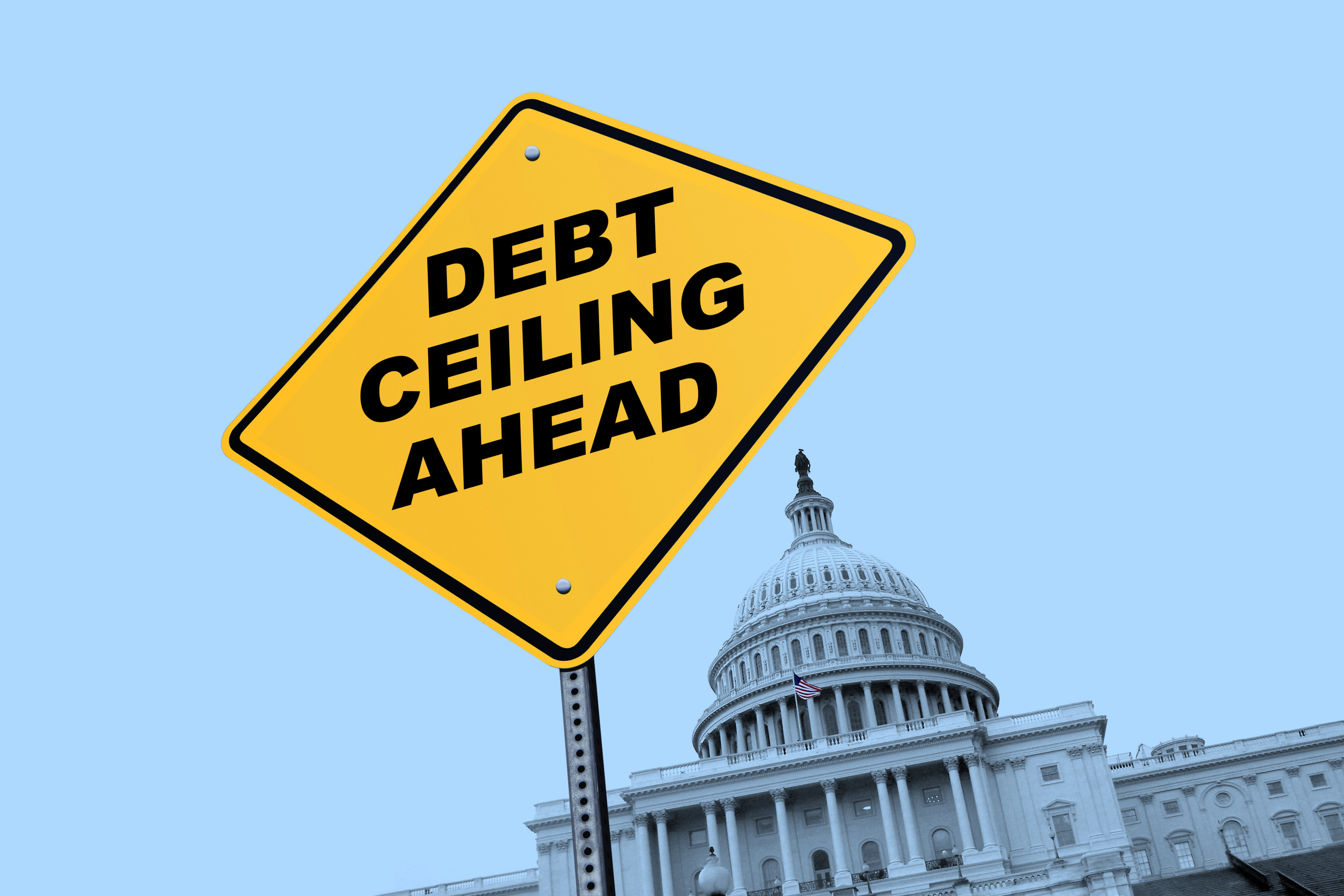 Road sign with "debt ceiling ahead" written on it, in front of the US Capitol building.