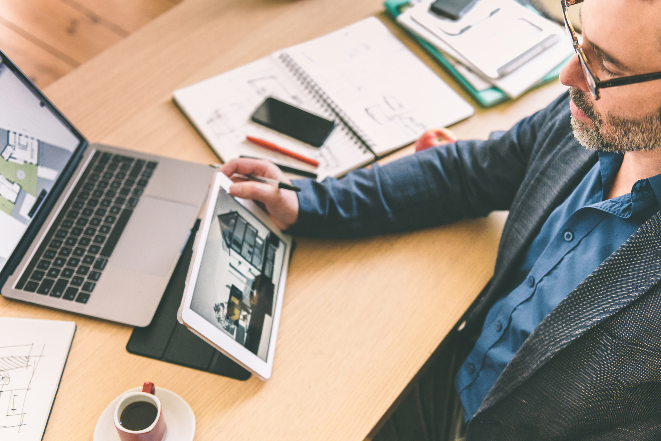 Person at laptop and iPad and looking at properties on both.