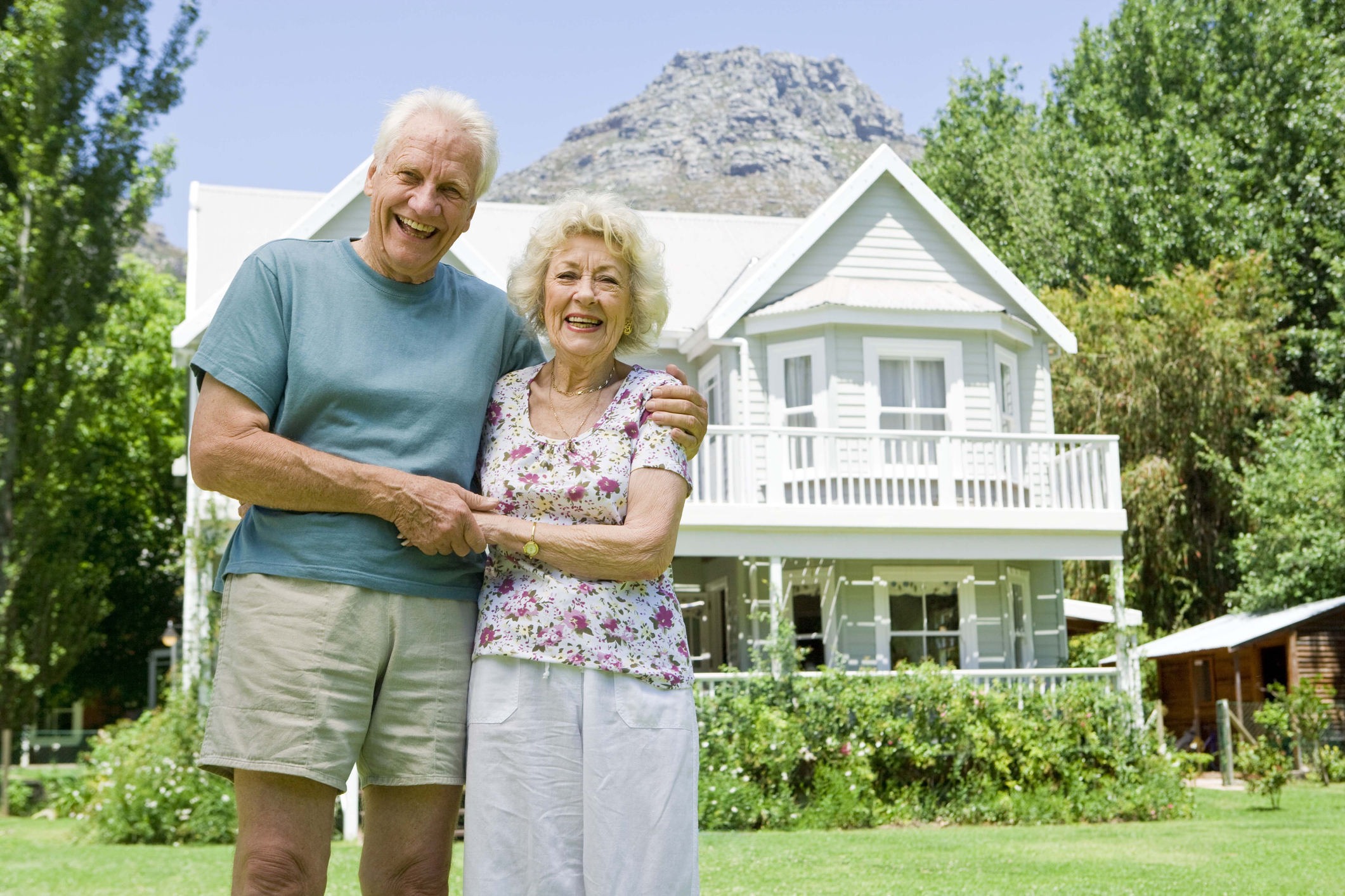 Two people standing in front of a house.