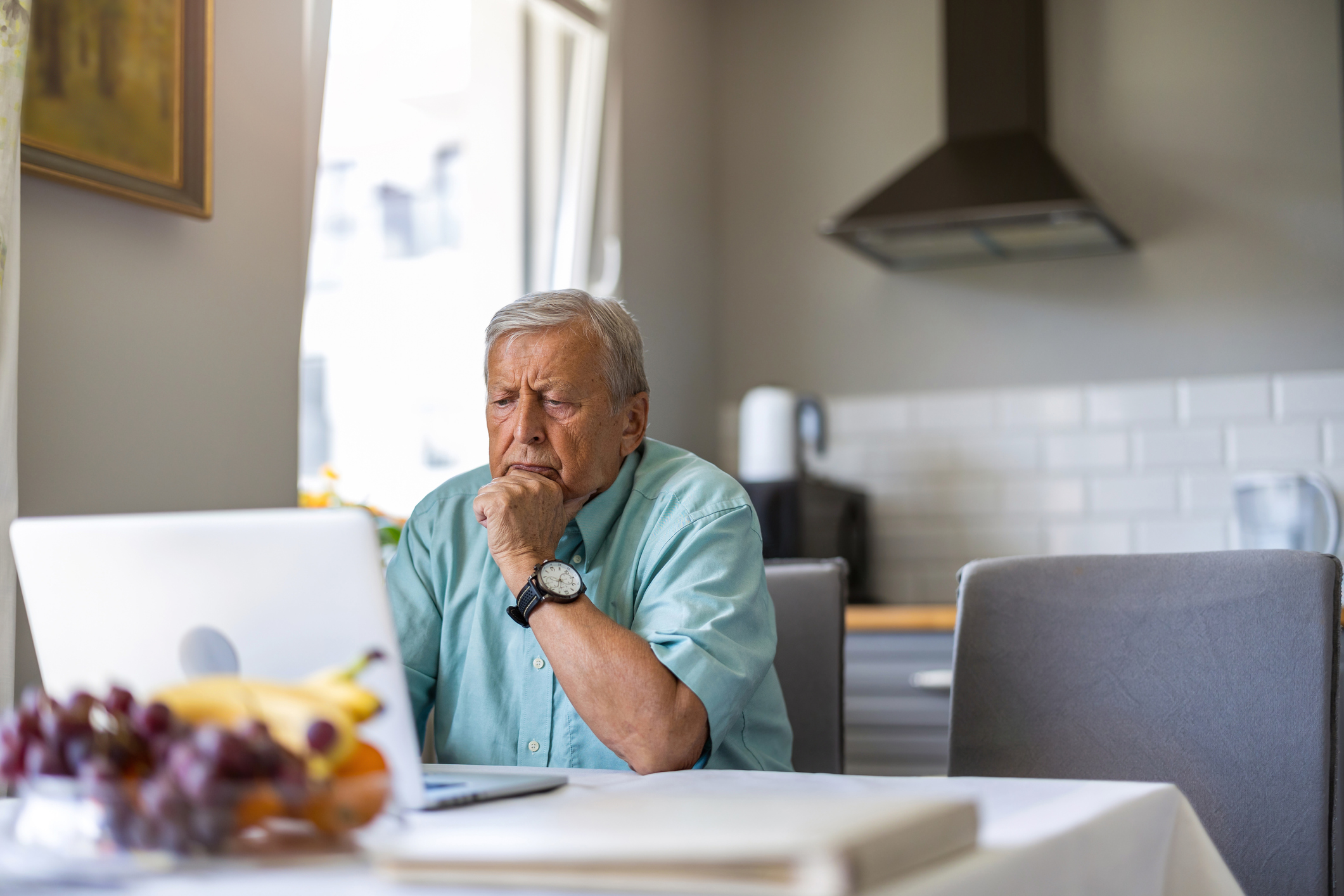 A person with a serious expression at a laptop.