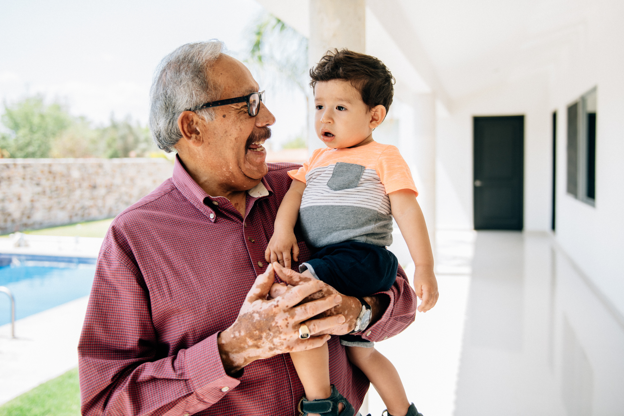A person smiling and holding a child.