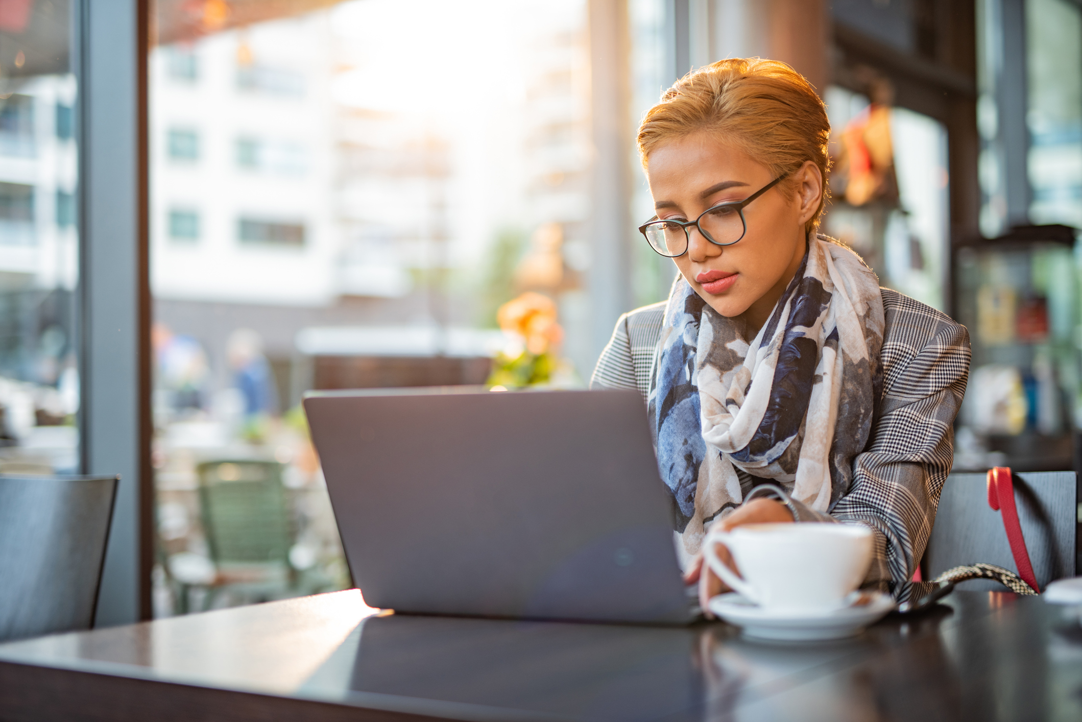 A person at a laptop with a serious expression.