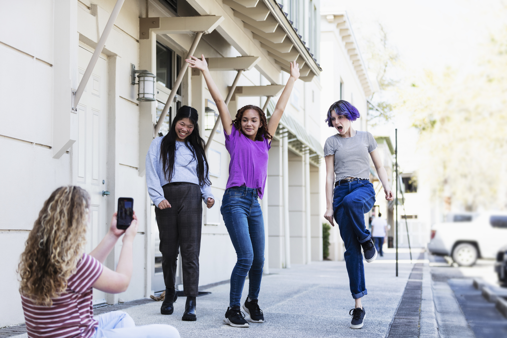 Tween filming friends with smart phone.