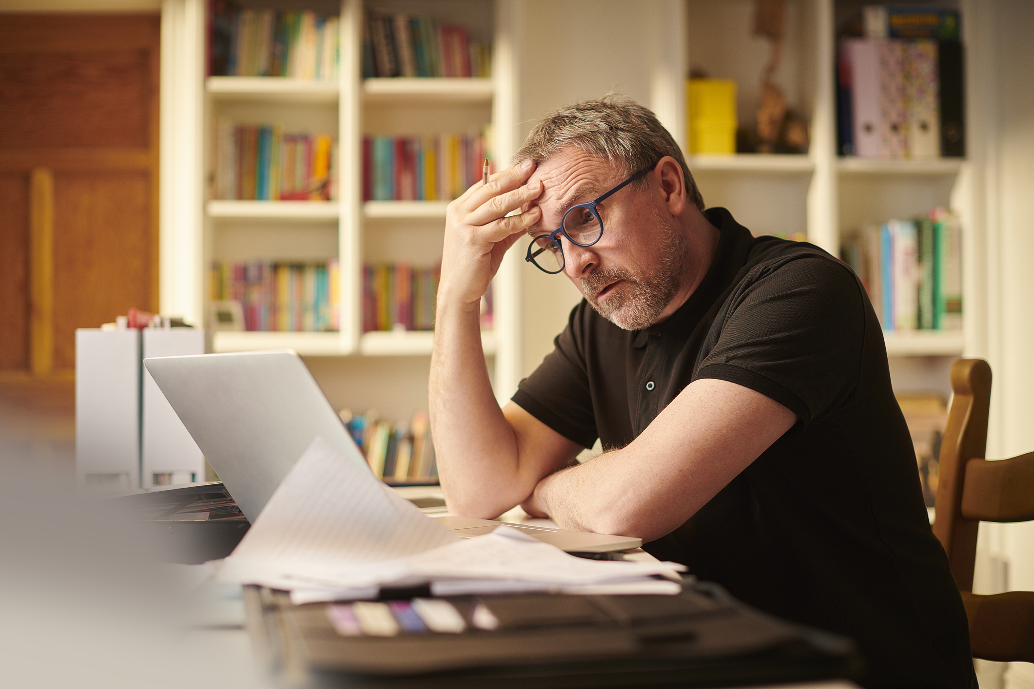A person with a serious expression at a laptop.