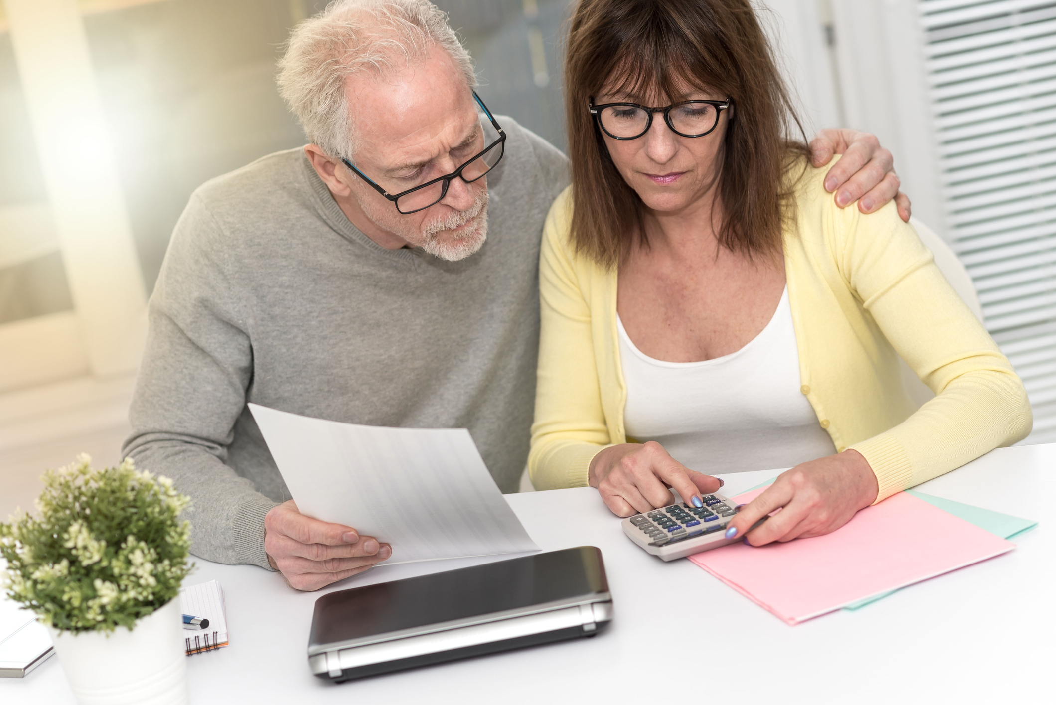 Two people looking at a document and a calculator.
