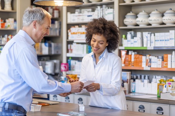 A pharmacist helping a customer with a medicine prescription.