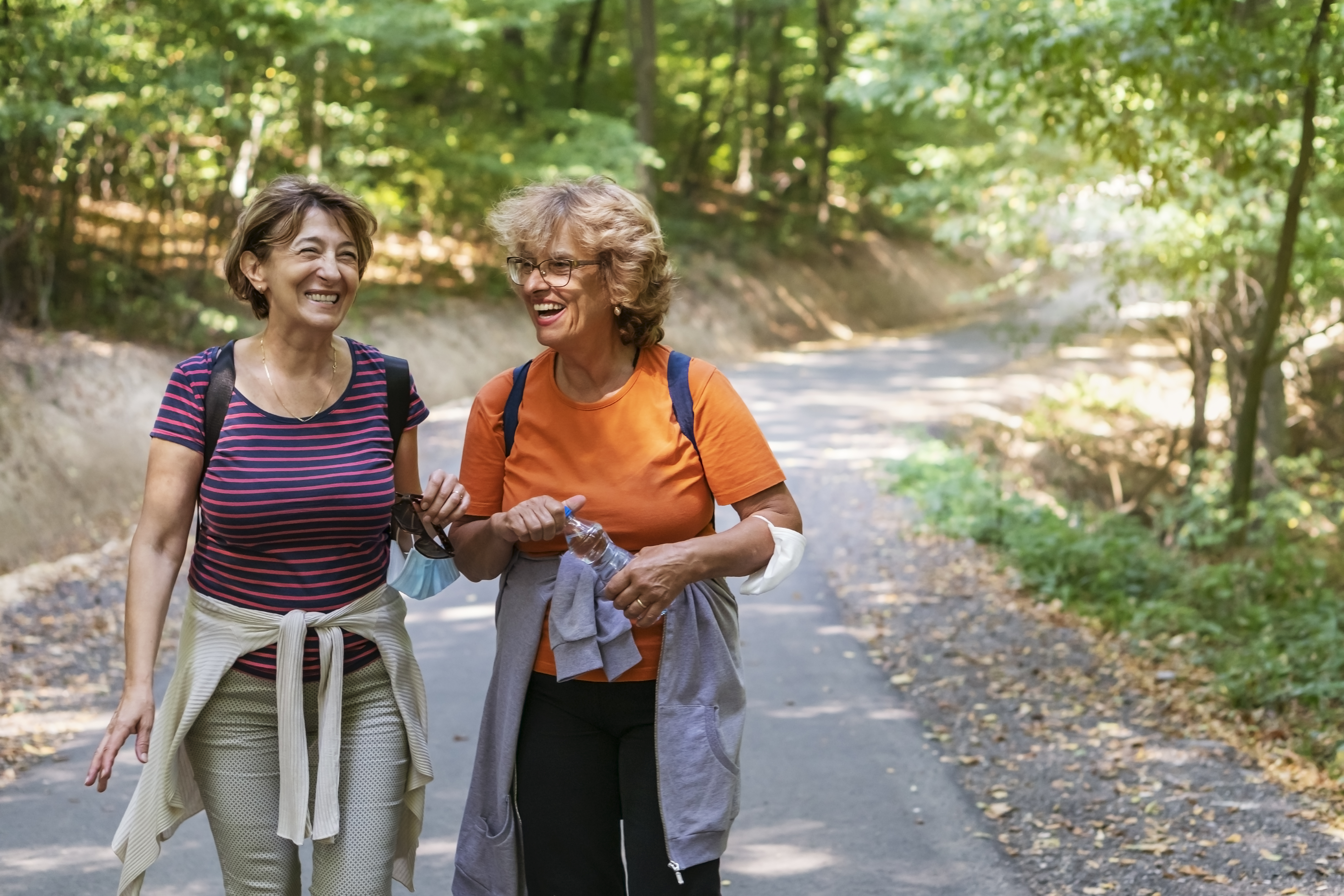 Two people walking outside on a trail.