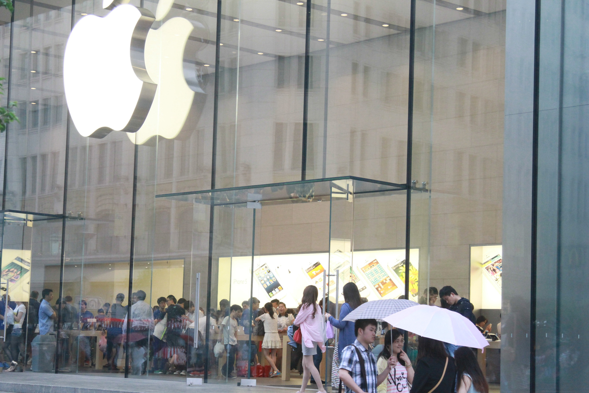 Exterior of an Apple Store with glass walls and large Apple logo.