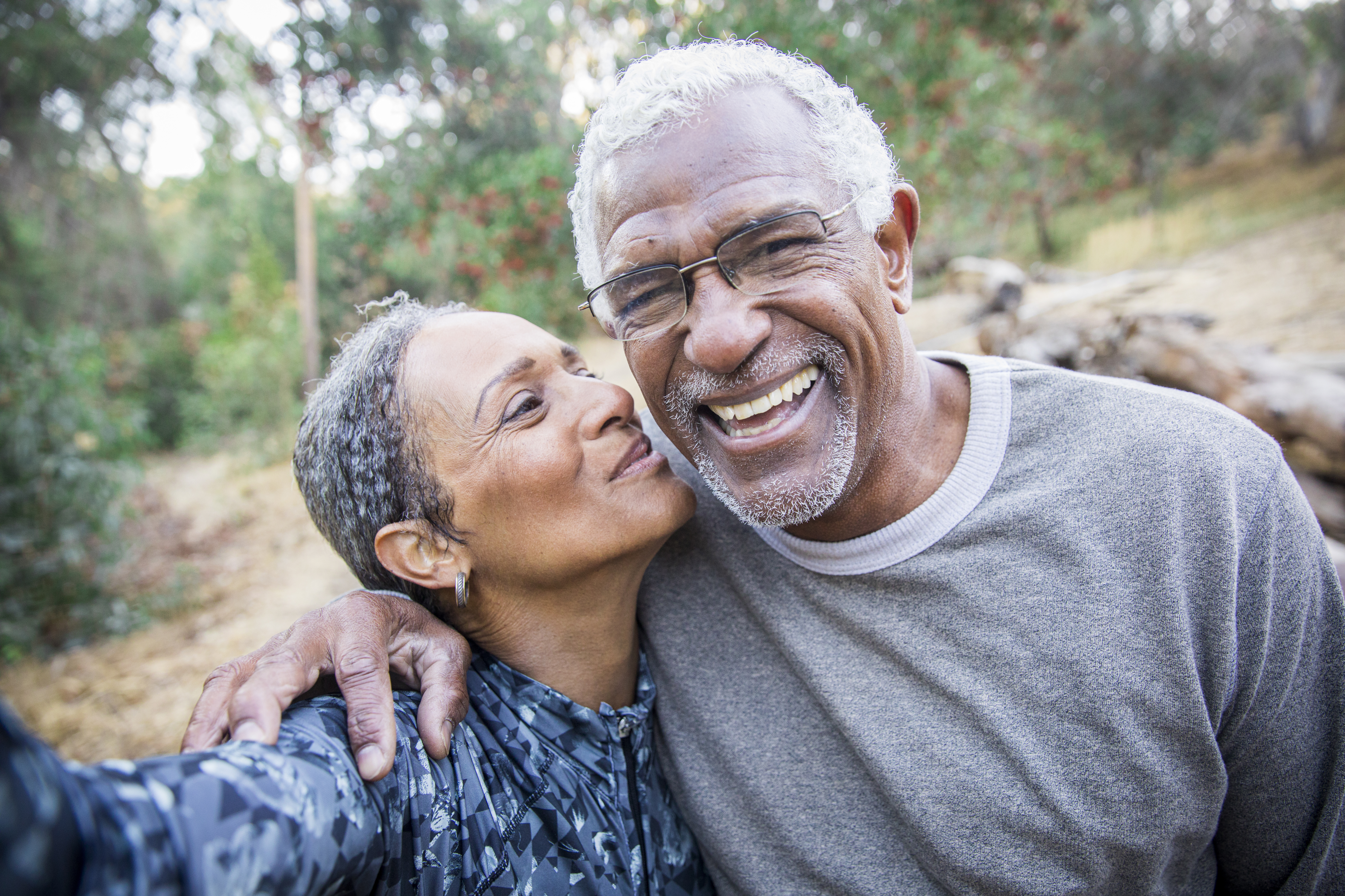 A couple is outdoors, smiling.