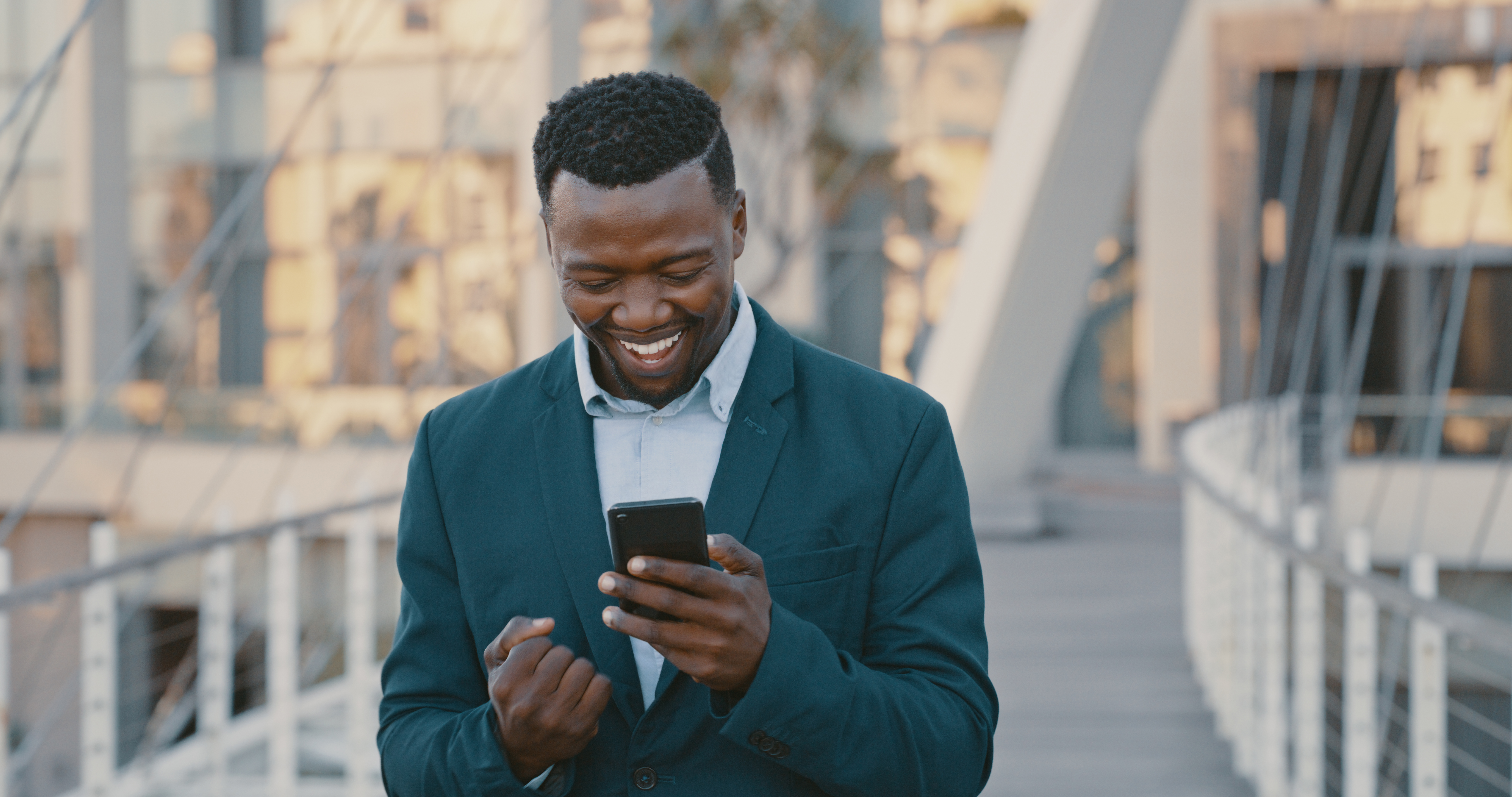 Guy pumps his fist at his smartphone.
