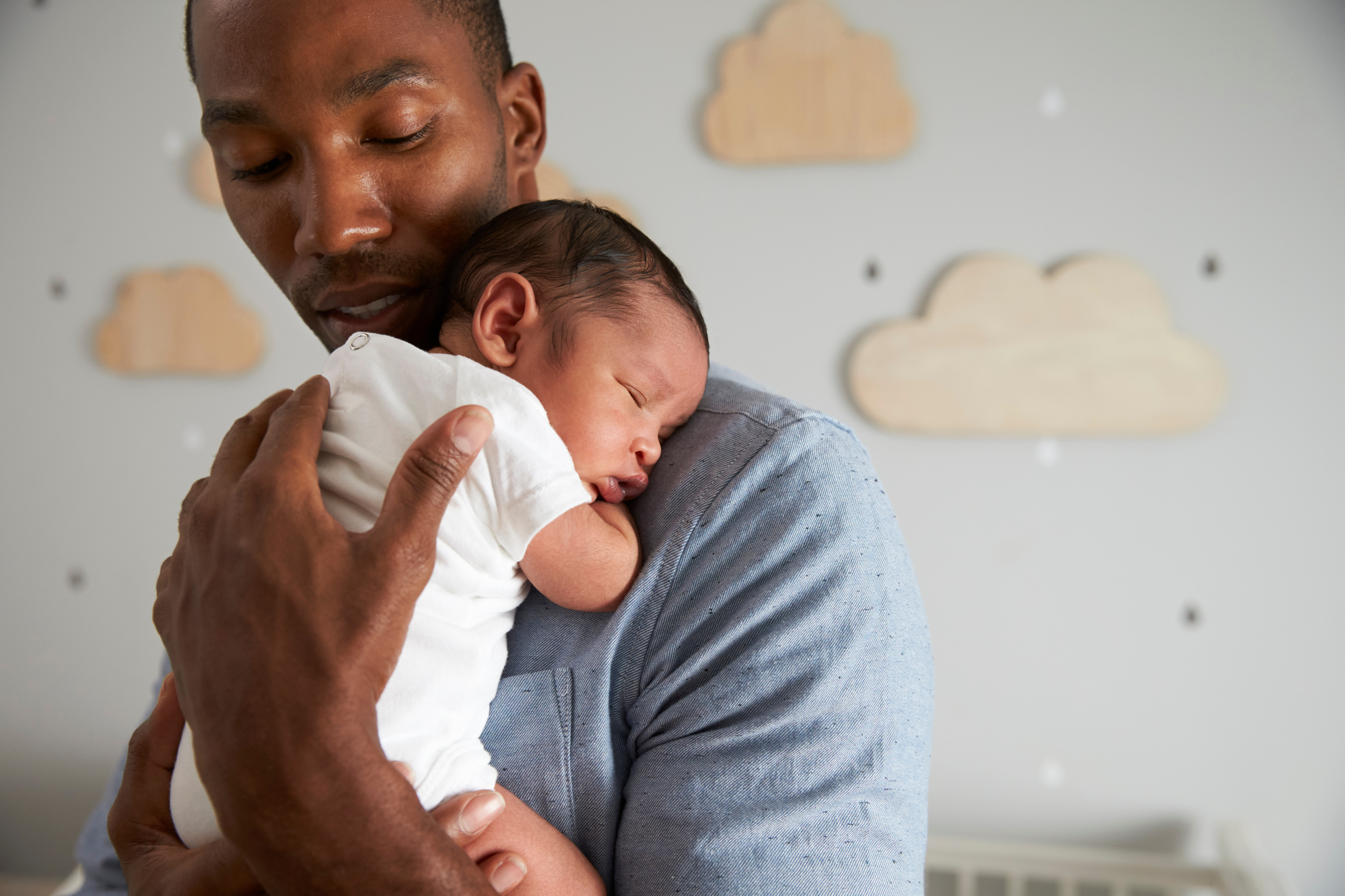 A parent holding their newborn child close to their chest.