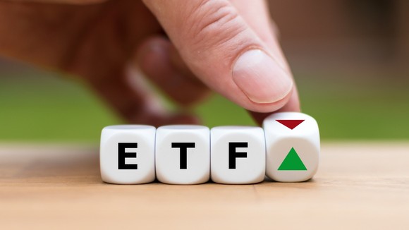 A hand turning blocks that spell out ETF.