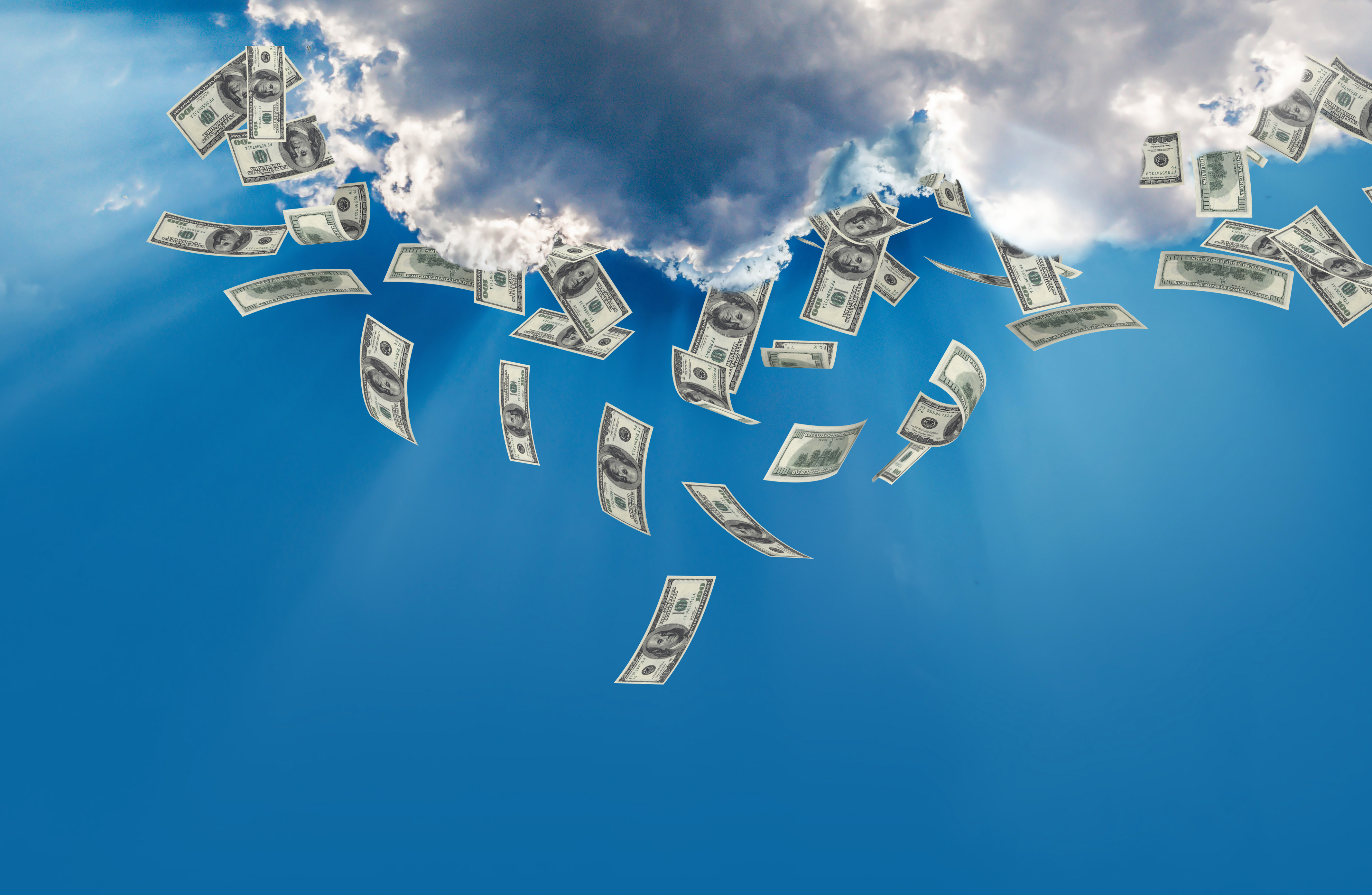 Dollar bills coming out of a cloud like rain.
