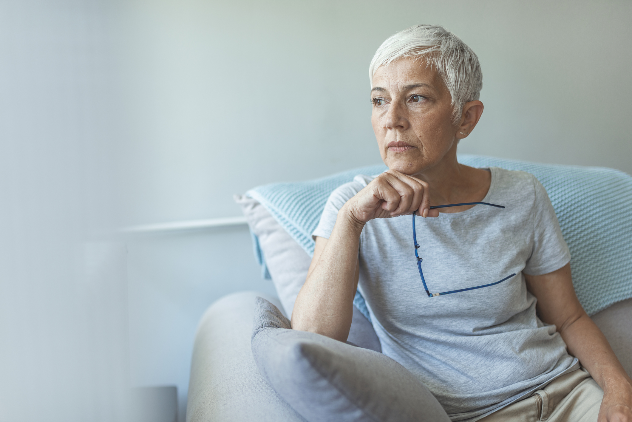 Person with a serious expression sitting in a chair.