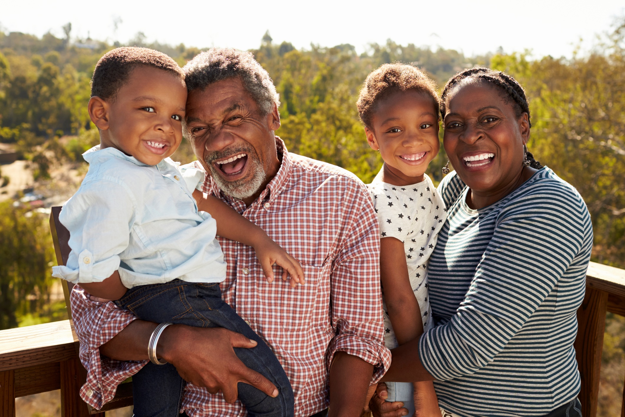 Two older folks holding two young kids.