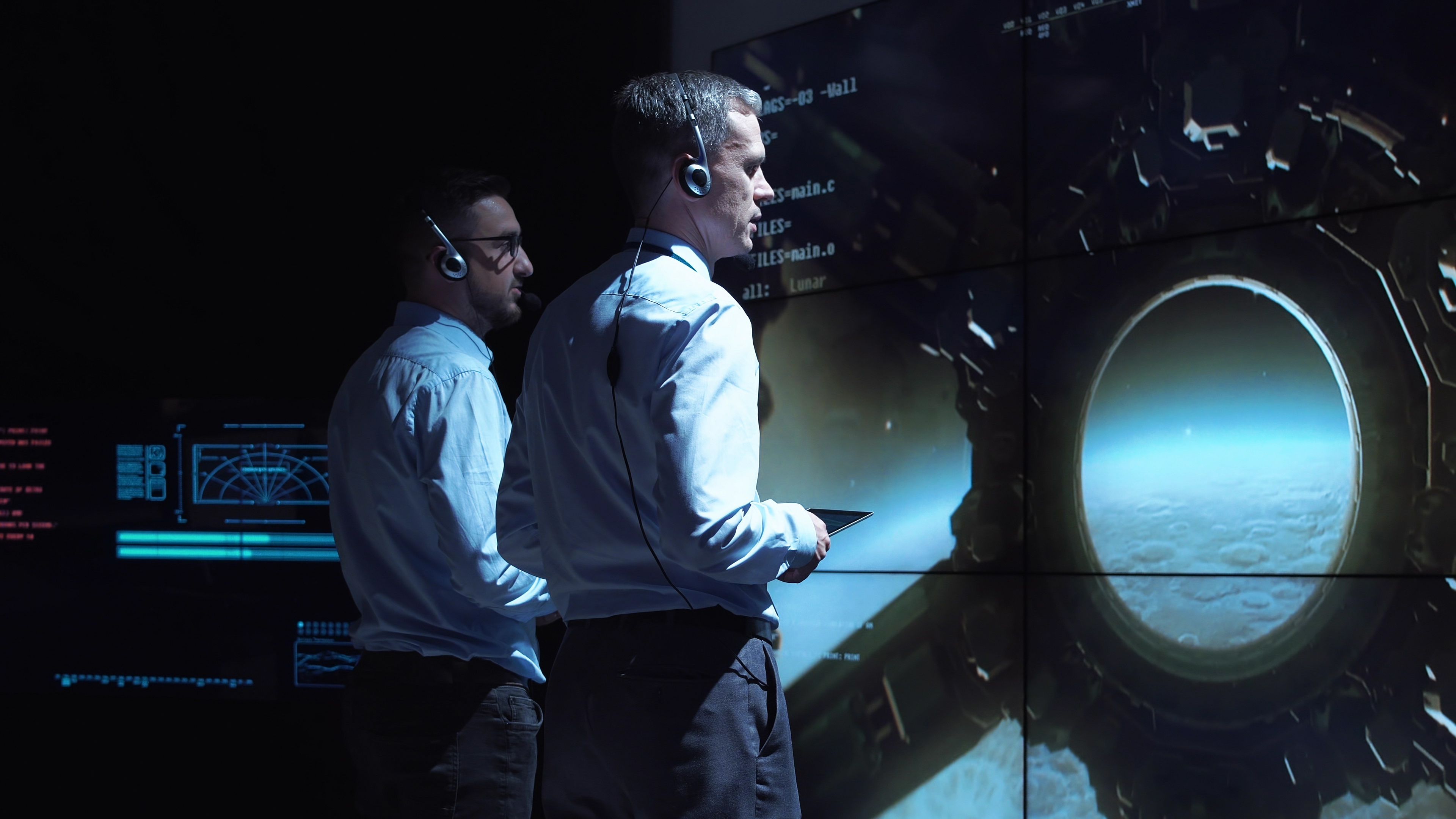 Astronauts looking out a portal in a space base.