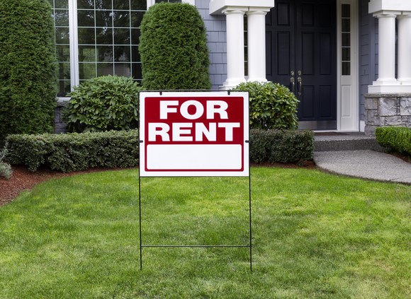 A house with a for rent sign in front of it.