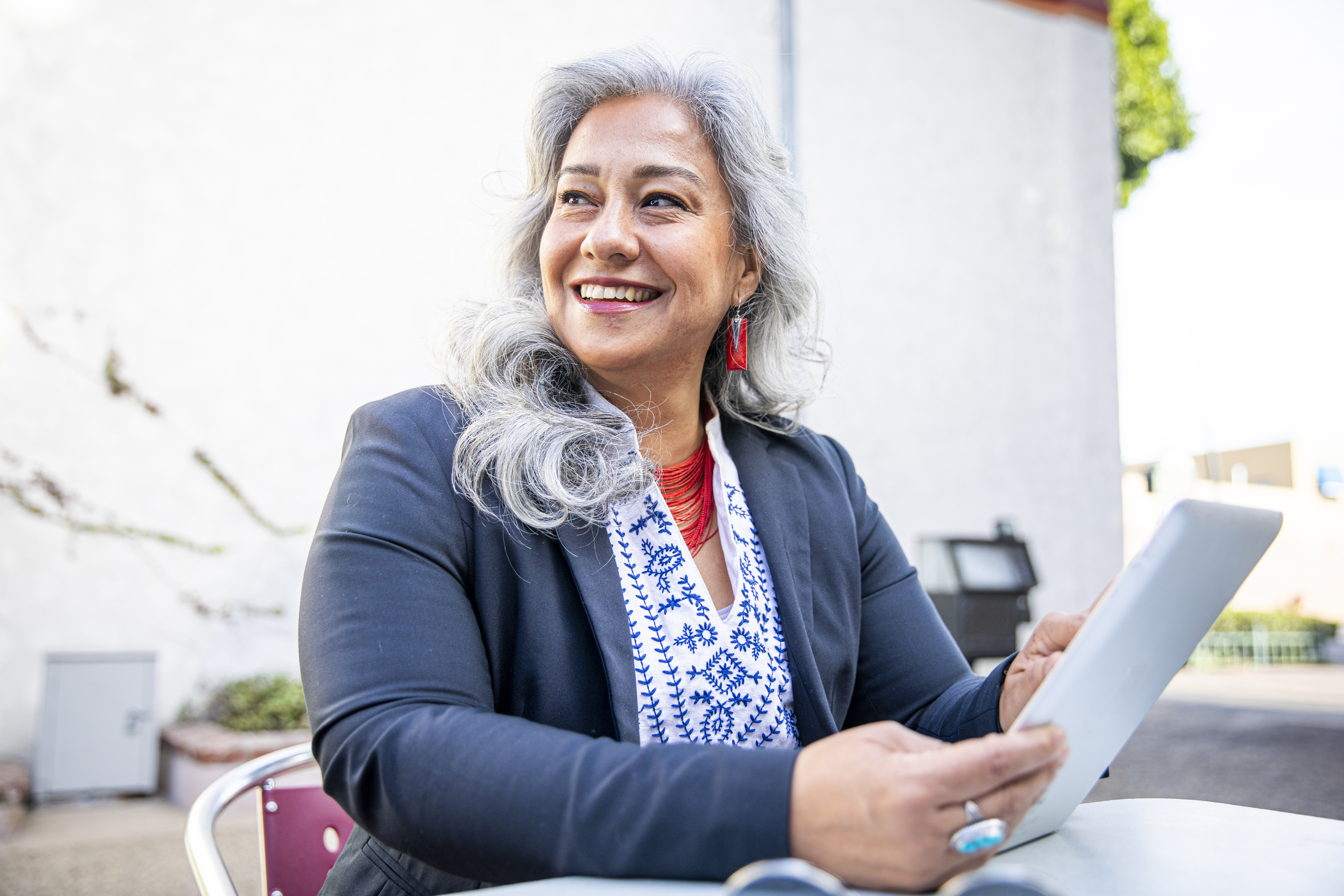 Person smiling and holding a tablet.