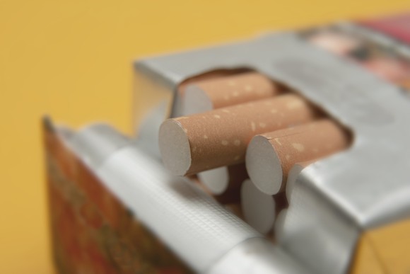 A pack of cigarettes with one poking out of the box.