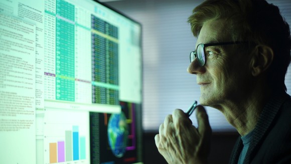 Serious man looking at financial data on a computer