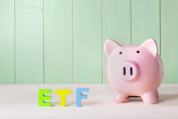 A piggybank next to wooden blocks that spell ETF.