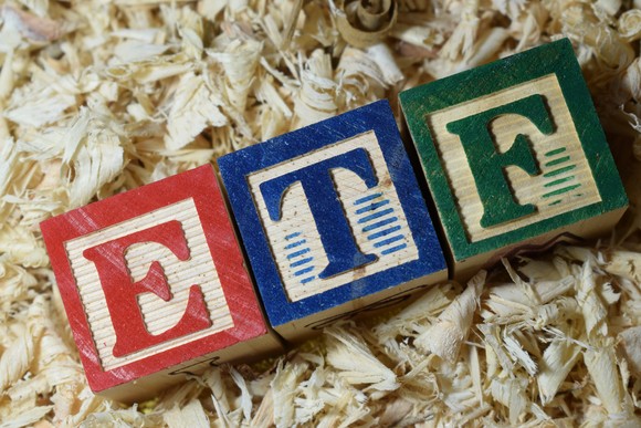 Blocks spelling ETF on a pile of wood shavings.