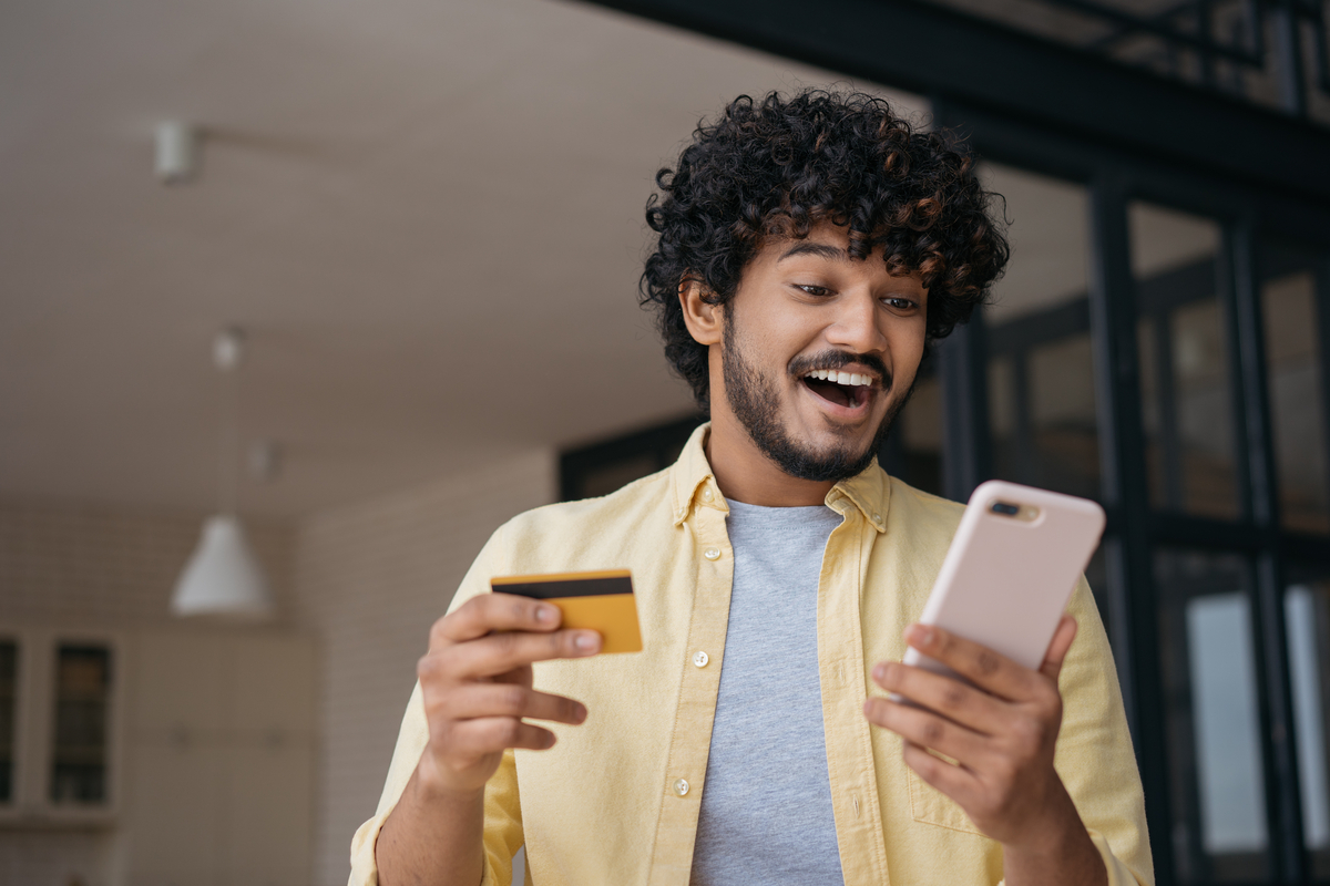 Person with credit card and mobile phone