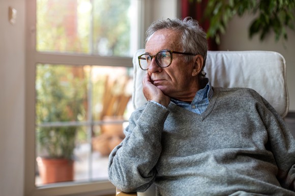 Person sitting in chair and looking outside.