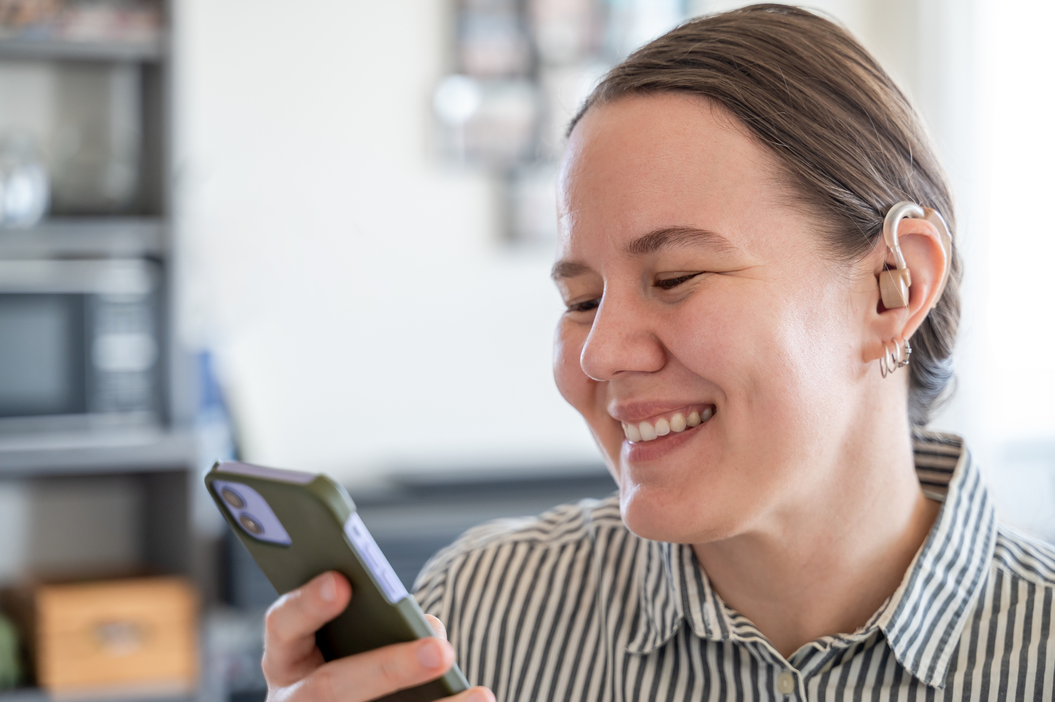 Getty - smiling at phone happy striped shirt