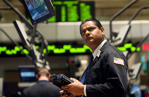 A New York Stock Exchange floor trader looking up in bewilderment at a computer screen.