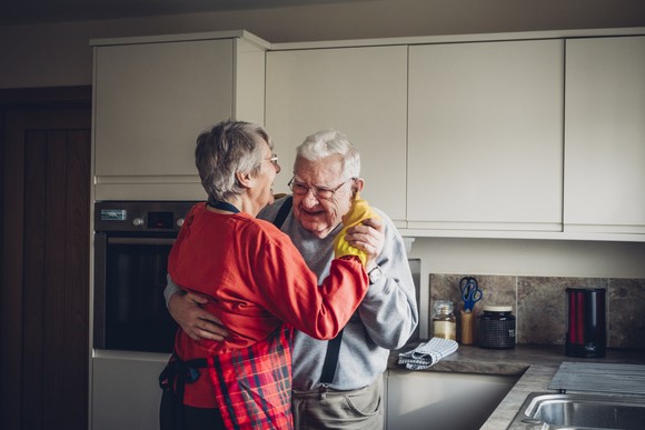 Two people dancing in a kitchen.