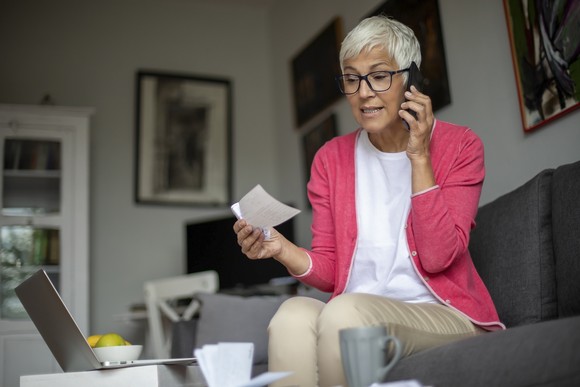 Person holding check and talking on the phone.