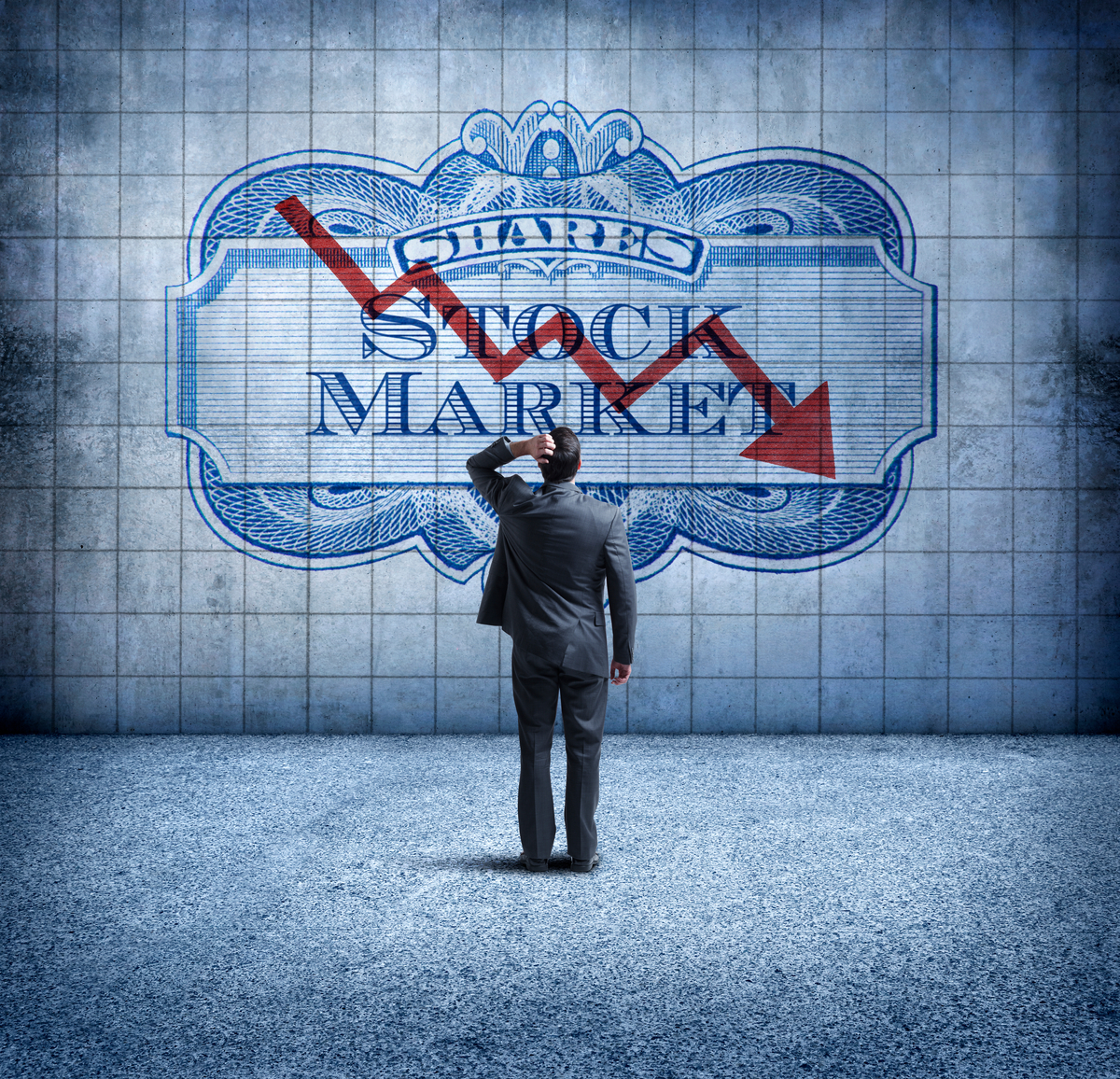 An investor looks at a sign that shows a down arrow over the words "stock market."