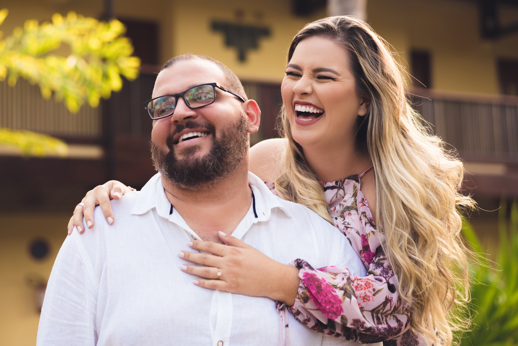 Two people outdoors, laughing and embracing.