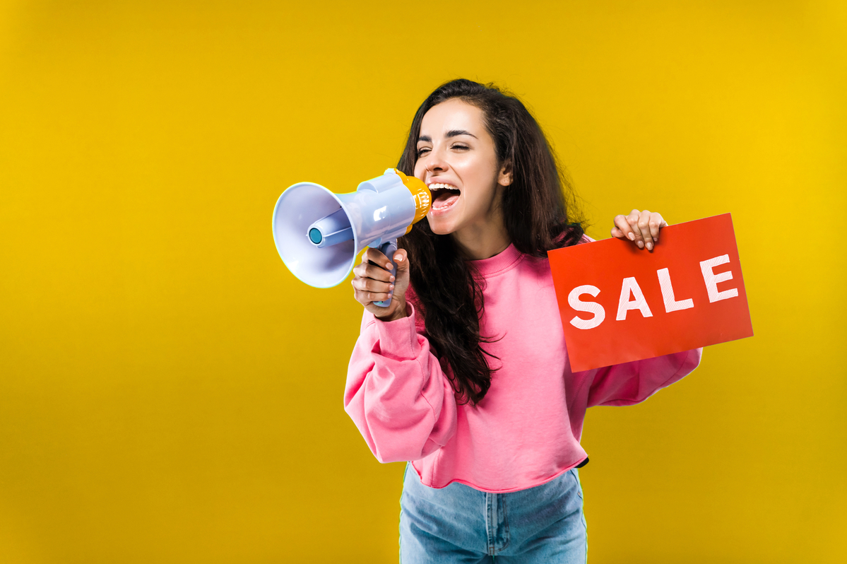 A person holding a sale sign.
