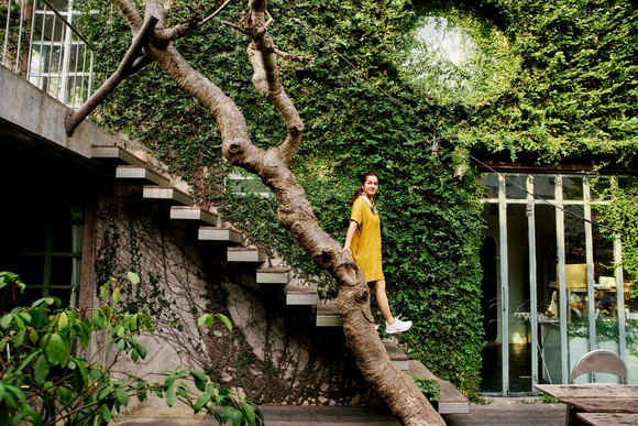 A woman walking down the stairs of an Airbnb in Thailand.