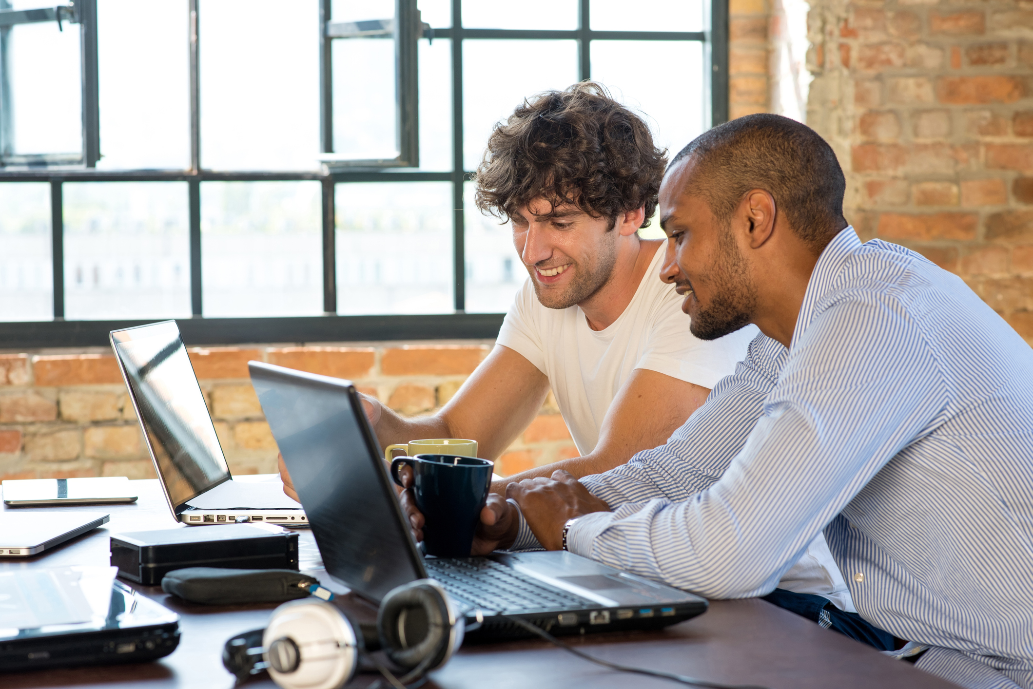 Two people working on their computers in a shared space.