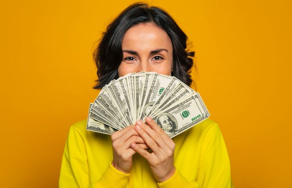 Person holding many hundred dollar bills.