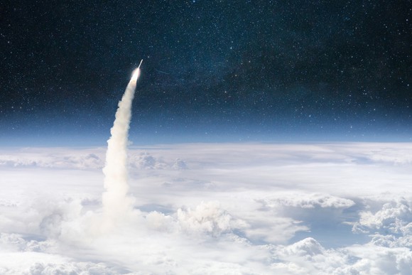 A rocket clearing a cloudbank and shooting into space.