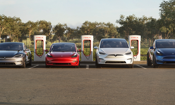 4 different Tesla models in a parking lot at a charging station.