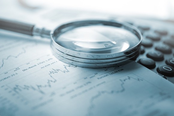 A magnifying glass lying on a newspaper.
