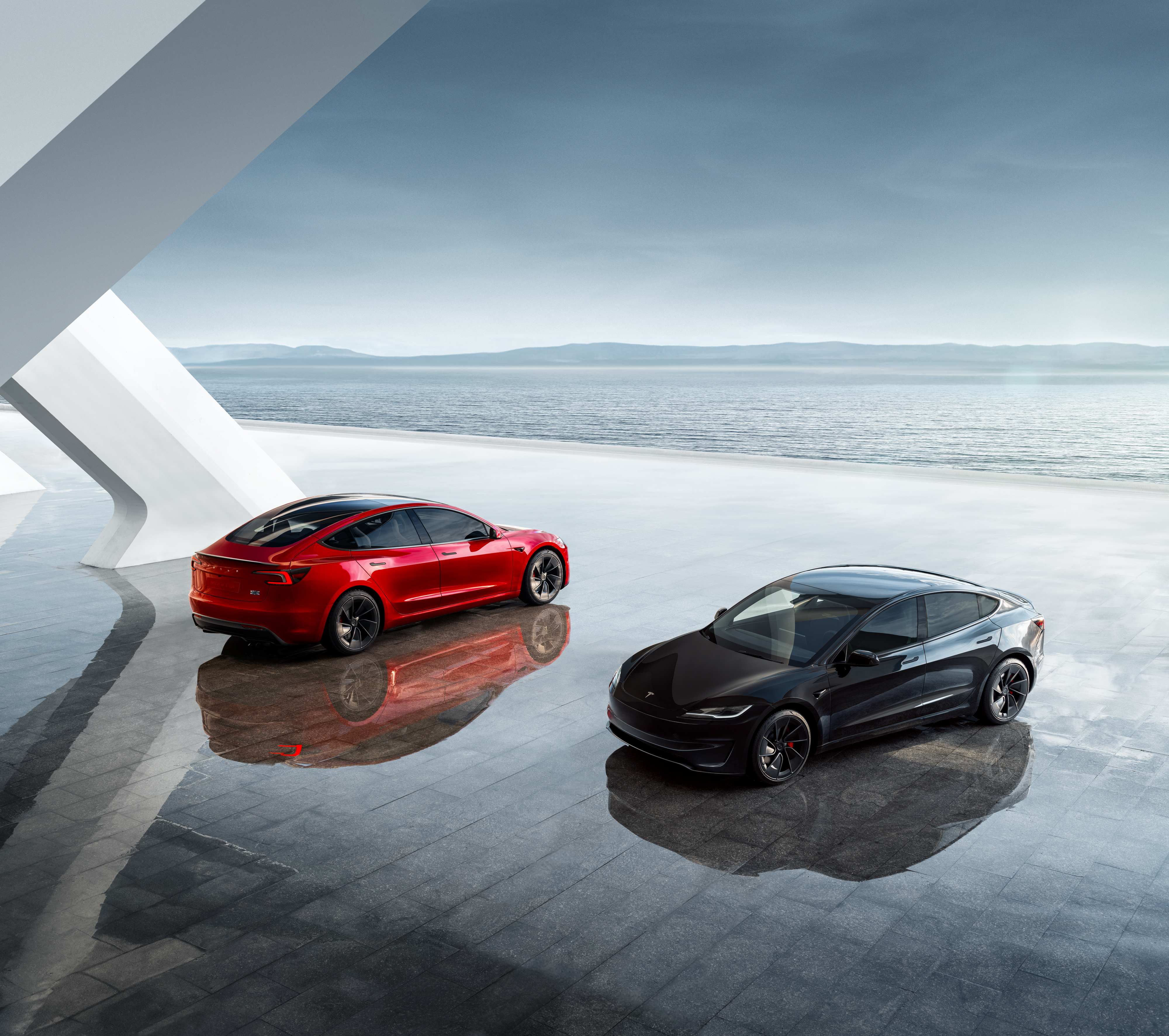 Red and black Tesla Model 3s on display.