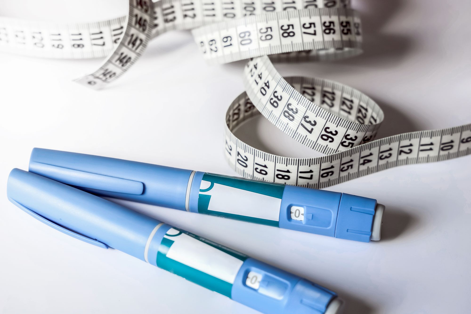 Measuring tape next to multiple injectable medications.