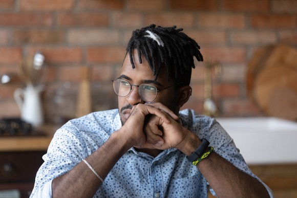 Person looking to the side in a reflective manner.