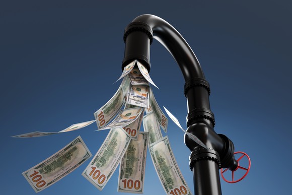 Cash pouring out of a faucet.