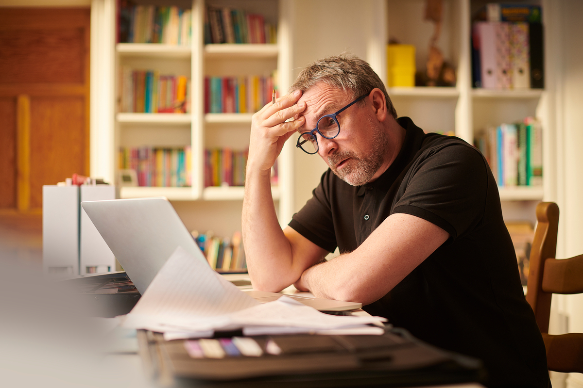 A stressed person staring at a laptop.