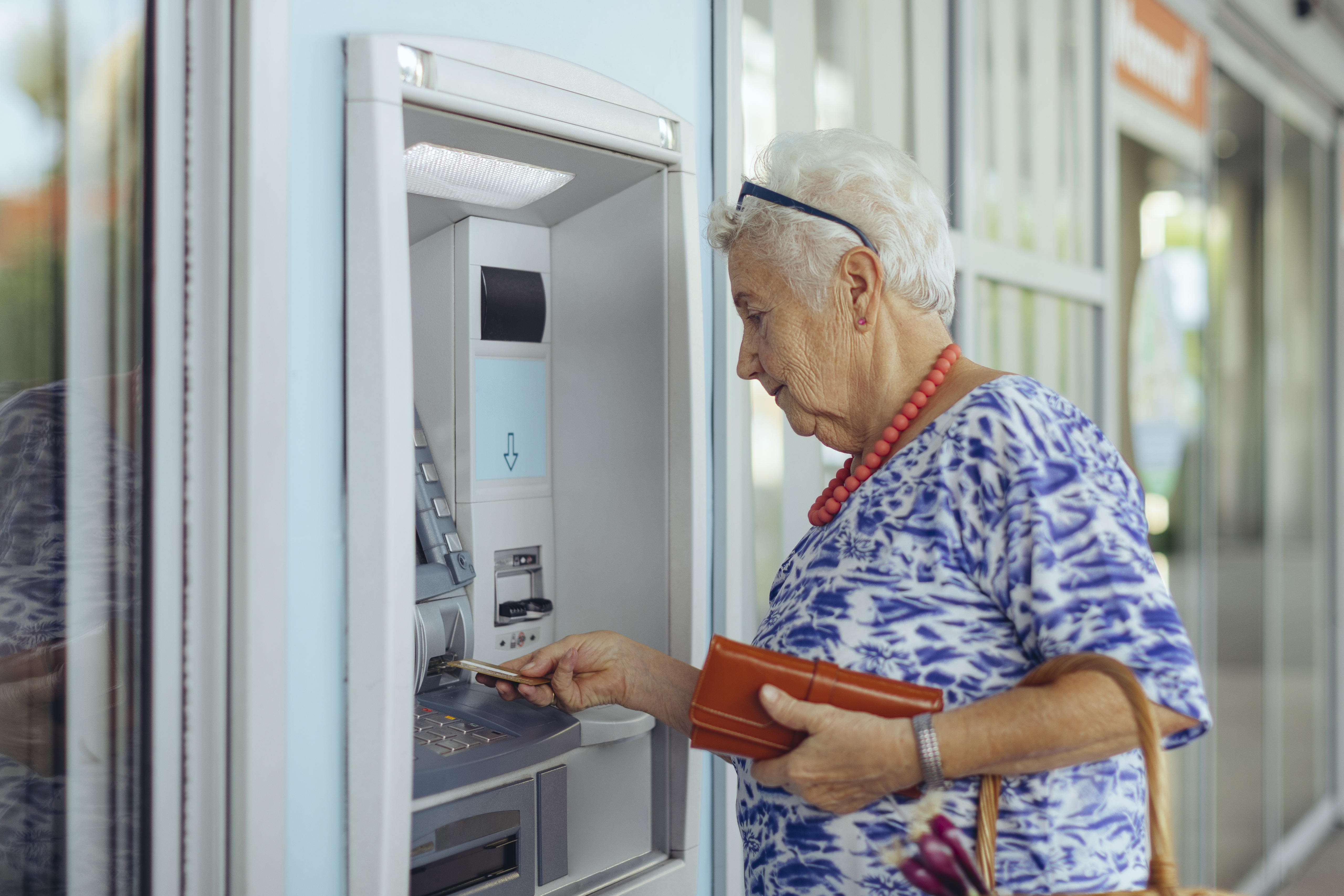 Person putting a card into ATM machine.