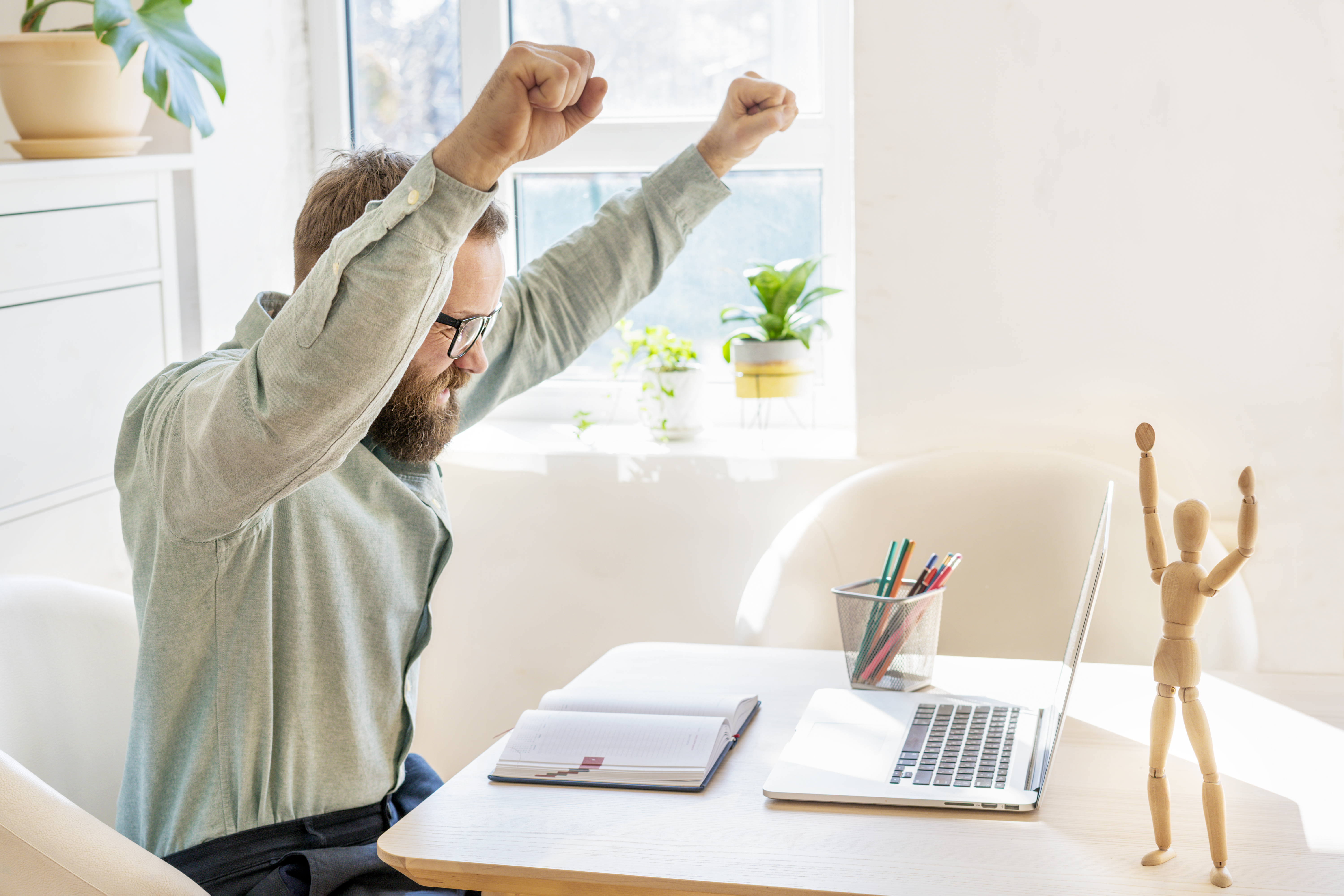 Person celebrating in front of a laptop.