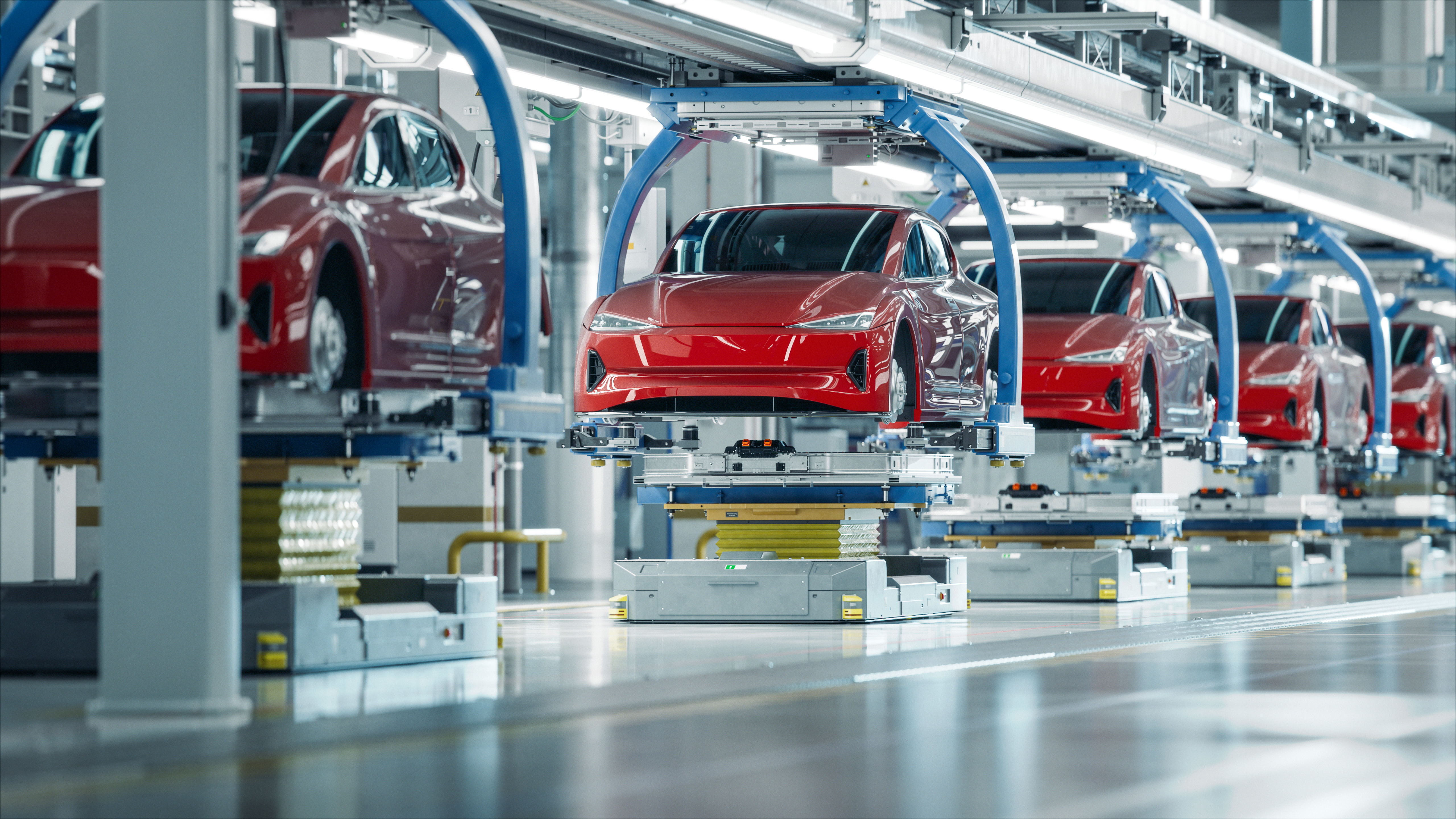 Red cars moving through an assembly line.