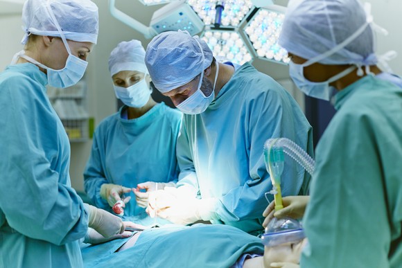 Physicians performing surgery in an operating room.